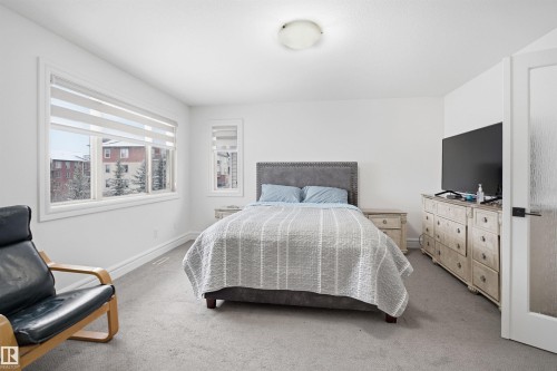 This room features neutral-toned carpeting, white walls, and a ceiling-mounted light fixture - 469 Ainslie Crescent Sw, Edmonton, AB - Indoor Photo Showing Bedroom