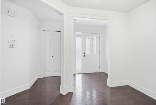 Entryway featuring dark hardwood flooring, white baseboards, and white walls - 469 Ainslie Crescent Sw, Edmonton, AB - Indoor Photo Showing Other Room