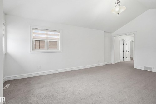 This spacious room features neutral-toned carpeting, white walls, and a window with blinds - 469 Ainslie Crescent Sw, Edmonton, AB - Indoor Photo Showing Other Room