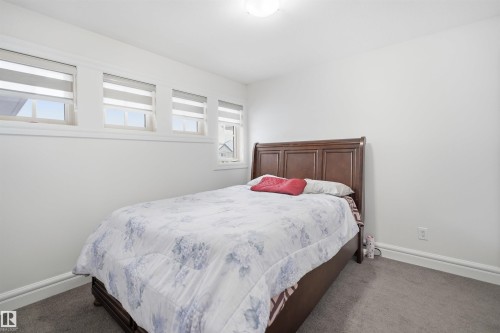 This room features light grey carpeting and white walls, creating a bright and neutral aesthetic - 469 Ainslie Crescent Sw, Edmonton, AB - Indoor Photo Showing Bedroom