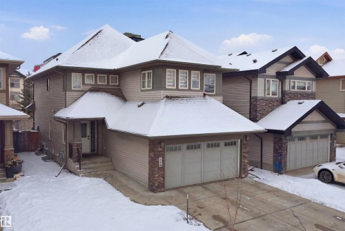 The property features a two-car garage, a covered front entryway, and a combination of siding and stone veneer on the exterior - 469 Ainslie Crescent Sw, Edmonton, AB - Outdoor