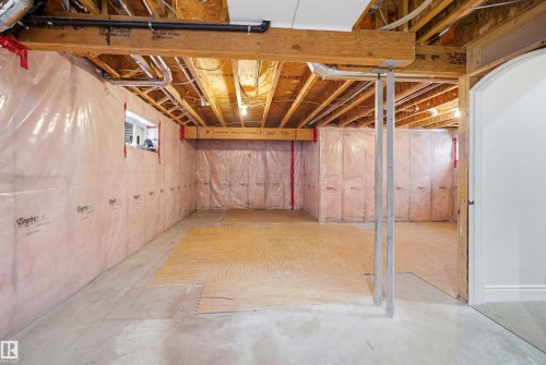 The property features an unfinished basement with exposed wooden beams, insulation, and a window - 469 Ainslie Crescent Sw, Edmonton, AB - Indoor Photo Showing Basement