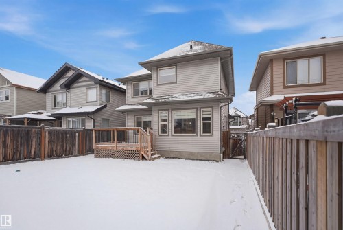 The property features a private fenced yard with a wooden deck, accessible from the rear of the home - 469 Ainslie Crescent Sw, Edmonton, AB - Outdoor