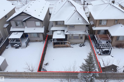 The property features a fenced backyard with a patio, a detached shed, and a mature evergreen tree - 469 Ainslie Crescent Sw, Edmonton, AB - Outdoor With Facade