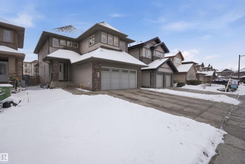 The property features a two-car garage, a covered front entrance, and an exterior combining siding and stone accents - 469 Ainslie Crescent Sw, Edmonton, AB - Outdoor With Facade