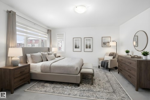 The property features a spacious bedroom with light-colored walls and flooring - 469 Ainslie Crescent Sw, Edmonton, AB - Indoor Photo Showing Bedroom