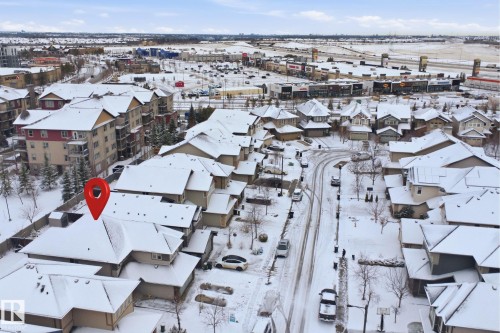 Aerial view of the property and its surrounding neighborhood, featuring residential buildings and commercial establishments - 469 Ainslie Crescent Sw, Edmonton, AB - Outdoor With View