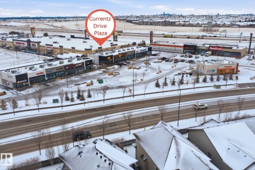 Aerial view highlighting the property's proximity to a commercial plaza featuring various businesses - 469 Ainslie Crescent Sw, Edmonton, AB - Outdoor With View