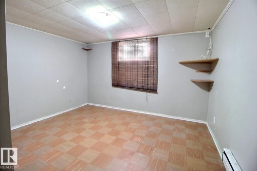 This room features neutral-toned walls, a window with blinds, and two corner wall shelves - 5109 49 Avenue, Andrew, AB - Indoor Photo Showing Other Room