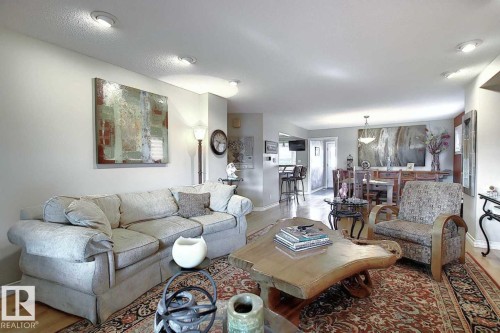 The property features hardwood floors, recessed lighting, and an open-concept layout that provides clear sightlines to the dining area and kitchen - 11126 52 Street, Edmonton, AB - Indoor Photo Showing Living Room