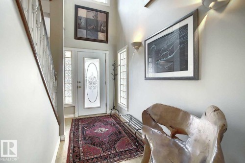 The entryway features a front door with decorative glass inserts, flanked by side windows, and a hardwood floor - 11126 52 Street, Edmonton, AB - Indoor Photo Showing Other Room