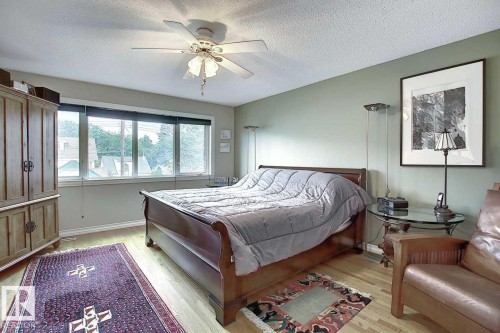Bedroom featuring hardwood flooring, a ceiling fan, and large windows providing natural light - 11126 52 Street, Edmonton, AB - Indoor Photo Showing Bedroom