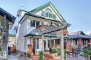 The property features white siding with green trim, a front porch with a wooden pergola, and a second-story balcony - 11126 52 Street, Edmonton, AB  - Outdoor With Deck Patio Veranda 