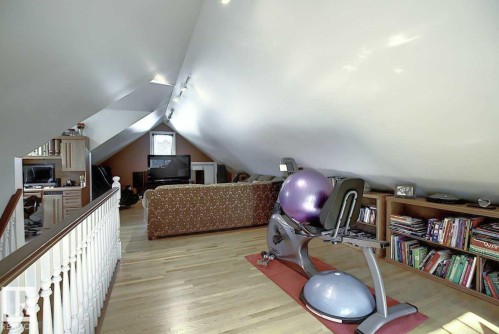 This versatile space features sloped ceilings, hardwood flooring, and recessed lighting - 11126 52 Street, Edmonton, AB - Indoor