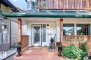 The property features a front porch with wood flooring and railings, a white exterior, and a glass-paneled front door - 11126 52 Street, Edmonton, AB  - Outdoor With Deck Patio Veranda With Exterior 