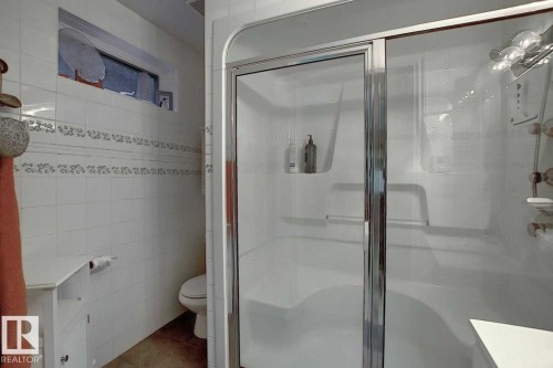 Bathroom featuring a shower with a sliding glass door and an overhead window - 11126 52 Street, Edmonton, AB - Indoor Photo Showing Bathroom