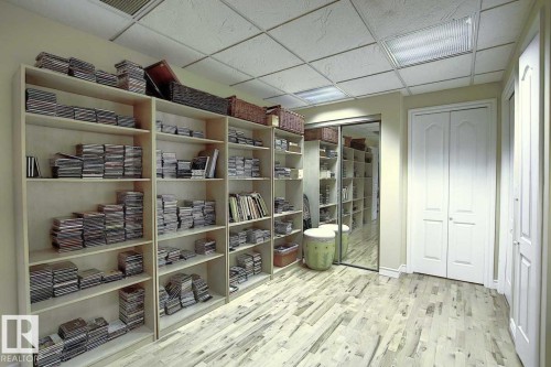This room features extensive built-in shelving, durable flooring, a mirrored closet, and two white bi-fold doors - 11126 52 Street, Edmonton, AB - Indoor
