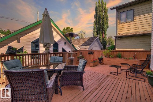 Expansive outdoor deck featuring a wooden railing, a privacy fence, and integrated planters with greenery - 11126 52 Street, Edmonton, AB - Outdoor With Deck Patio Veranda With Exterior
