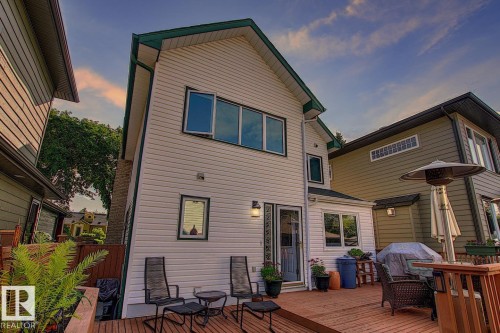 The property features a spacious deck with outdoor seating, an exterior door, and large windows providing ample natural light - 11126 52 Street, Edmonton, AB - Outdoor With Deck Patio Veranda With Exterior