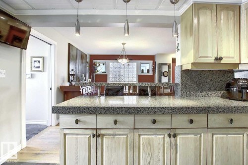 Kitchen featuring light wood cabinetry with dark hardware, granite countertops, and pendant lighting - 11126 52 Street, Edmonton, AB - Indoor Photo Showing Kitchen
