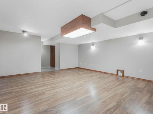 The property features light wood flooring, neutral-toned walls, and a variety of ceiling-mounted lighting fixtures - 11704 11 Avenue, Edmonton, AB - Indoor Photo Showing Other Room