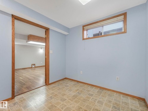 This interior space features pale blue walls, a window with blinds, and tiled flooring - 11704 11 Avenue, Edmonton, AB - Indoor Photo Showing Other Room