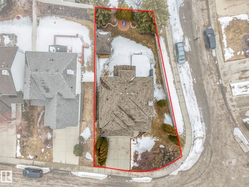 Aerial view of the property, showcasing its extensive lot with a driveway, a sloped yard, and a patio area - 11704 11 Avenue, Edmonton, AB - 