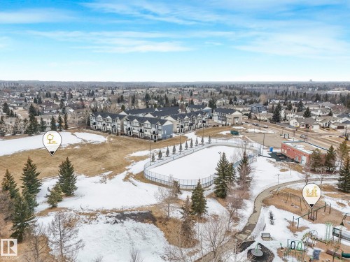 Aerial view of the surrounding neighbourhood, featuring townhouses, an ice rink, and a play area - 11704 11 Avenue, Edmonton, AB - Outdoor With View