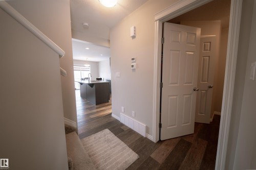 Entryway with wood-look flooring and a light-colored area rug - 2132 52 St, Edmonton, AB - Indoor Photo Showing Other Room