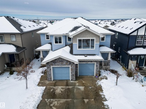 This property features a light blue exterior with stone facade accents and a double garage - 2132 52 St, Edmonton, AB - Outdoor With Facade