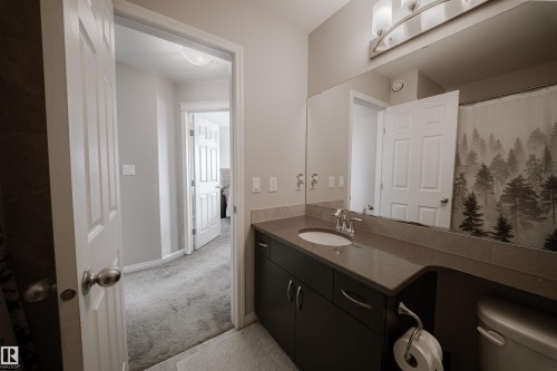 Bathroom featuring a vanity with an integrated sink, a large mirror, and overhead lighting - 2132 52 St, Edmonton, AB - Indoor Photo Showing Bathroom