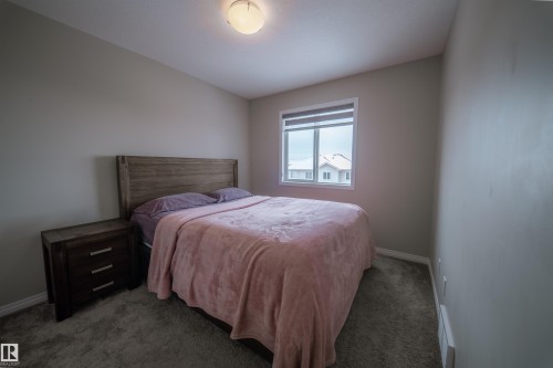 This room features a window with blinds, carpeted flooring, and neutral-toned walls - 2132 52 St, Edmonton, AB - Indoor Photo Showing Bedroom