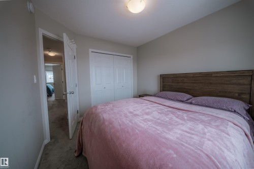 Bedroom featuring light gray walls, carpeted flooring, and a wooden headboard - 2132 52 St, Edmonton, AB - Indoor Photo Showing Bedroom