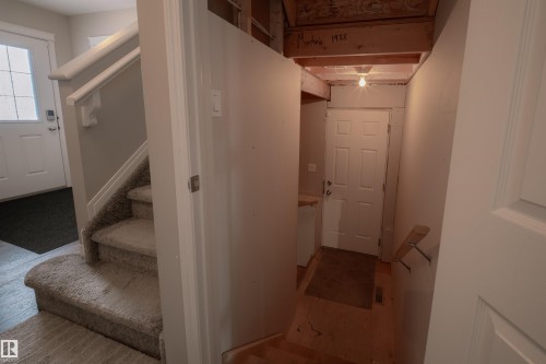 Entryway featuring a carpeted staircase with a white railing, a white paneled door, and wood flooring - 2132 52 St, Edmonton, AB - Indoor Photo Showing Other Room