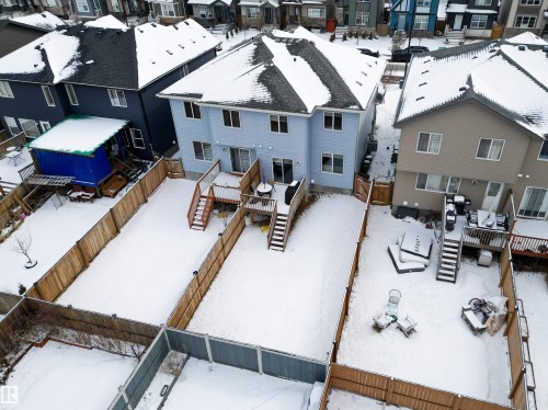 The property features a light blue exterior, a dark roof, and a wooden deck - 2132 52 St, Edmonton, AB - Outdoor With Deck Patio Veranda