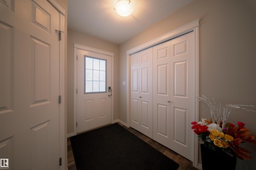 Entryway with light-colored walls, a white paneled door with a window, and a white bi-fold closet door - 2132 52 St, Edmonton, AB - Indoor Photo Showing Other Room