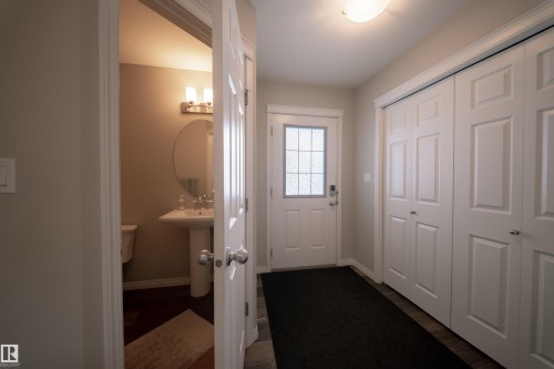 Entryway featuring a white paneled door with a frosted glass insert, a ceiling light fixture, and white bi-fold closet doors - 2132 52 St, Edmonton, AB - Indoor Photo Showing Other Room
