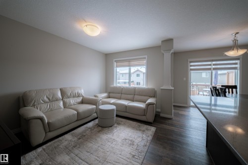 Living area featuring dark flooring, light-colored walls, and a decorative column - 2132 52 St, Edmonton, AB - Indoor Photo Showing Living Room