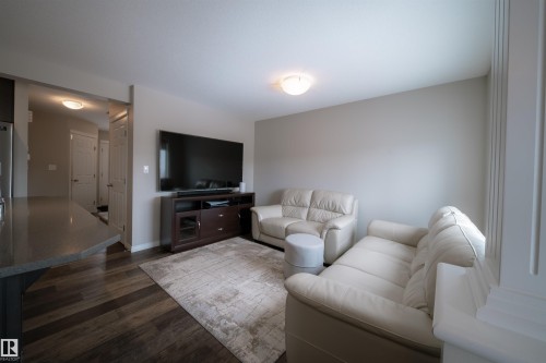 The property features hardwood style flooring, light colored walls, and a recessed ceiling light fixture - 2132 52 St, Edmonton, AB - Indoor Photo Showing Living Room