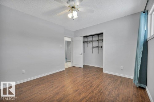 This room features wood-look flooring, light grey walls, and a ceiling fan with integrated lighting - 12140 53 Street, Edmonton, AB - Indoor Photo Showing Other Room