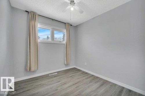 This room features light grey walls, light-colored flooring, and a window providing natural light - 12140 53 Street, Edmonton, AB - Indoor Photo Showing Other Room