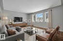 Living area featuring light gray walls, wood-finish flooring, and multiple windows - 12140 53 Street, Edmonton, AB  - Indoor Photo Showing Living Room 