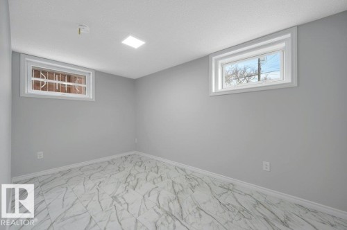 This room features light grey walls, white trim, and a patterned tile floor - 12140 53 Street, Edmonton, AB - Indoor Photo Showing Other Room