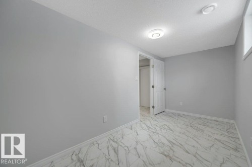 This room features light gray walls, a white ceiling, and white baseboards - 12140 53 Street, Edmonton, AB - Indoor Photo Showing Other Room