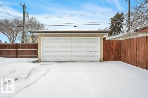 The property features a detached garage with a white garage door and a paved driveway - 12140 53 Street, Edmonton, AB - Outdoor