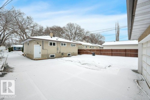 The property features a stucco exterior, a fenced yard, and a paved driveway - 12140 53 Street, Edmonton, AB - Outdoor