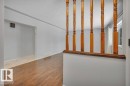 Entryway featuring hardwood flooring, a wooden banister, and light grey walls - 12140 53 Street, Edmonton, AB  - Indoor Photo Showing Other Room 