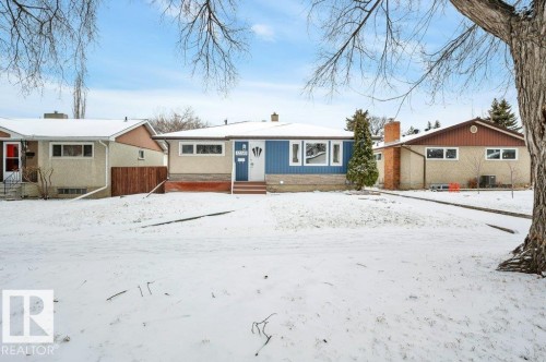 The property features a blue and tan exterior with white trim windows and a light blue front door - 12140 53 Street, Edmonton, AB - Outdoor