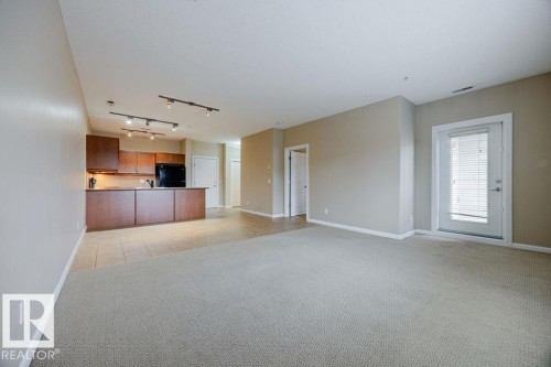 This shows the living room looking back to the kitchen. Notice that the main living area is totally open. - 217 160 Magrath Road, Edmonton, AB - Indoor Photo Showing Other Room