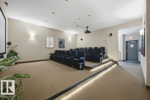 This property features a dedicated media room with tiered seating and a projector - 217 160 Magrath Road, Edmonton, AB - Indoor Photo Showing Other Room